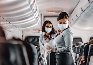 Two people complying with the face mask mandate on a commercial airline flight